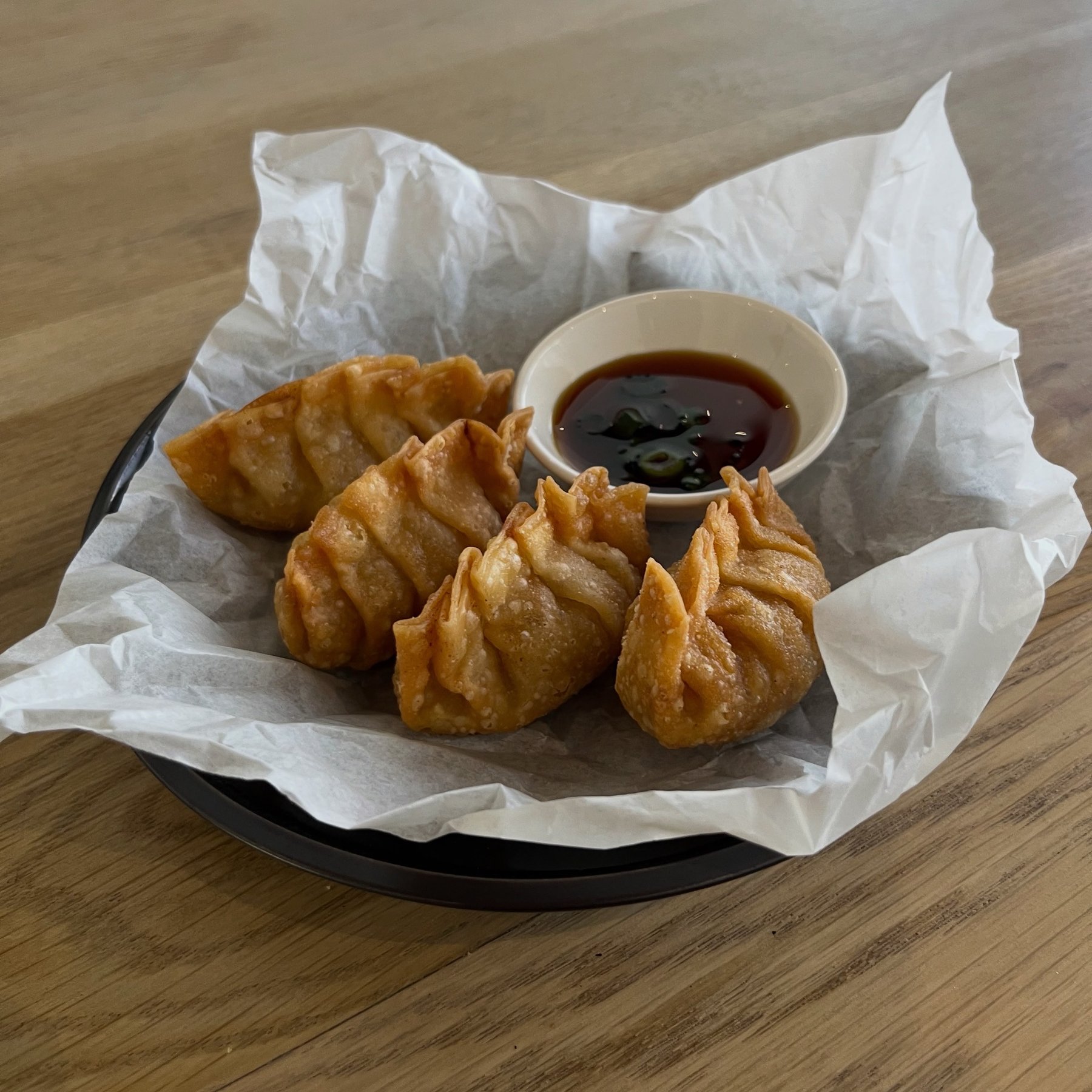 A plated dumpling dish with dipping sauce
