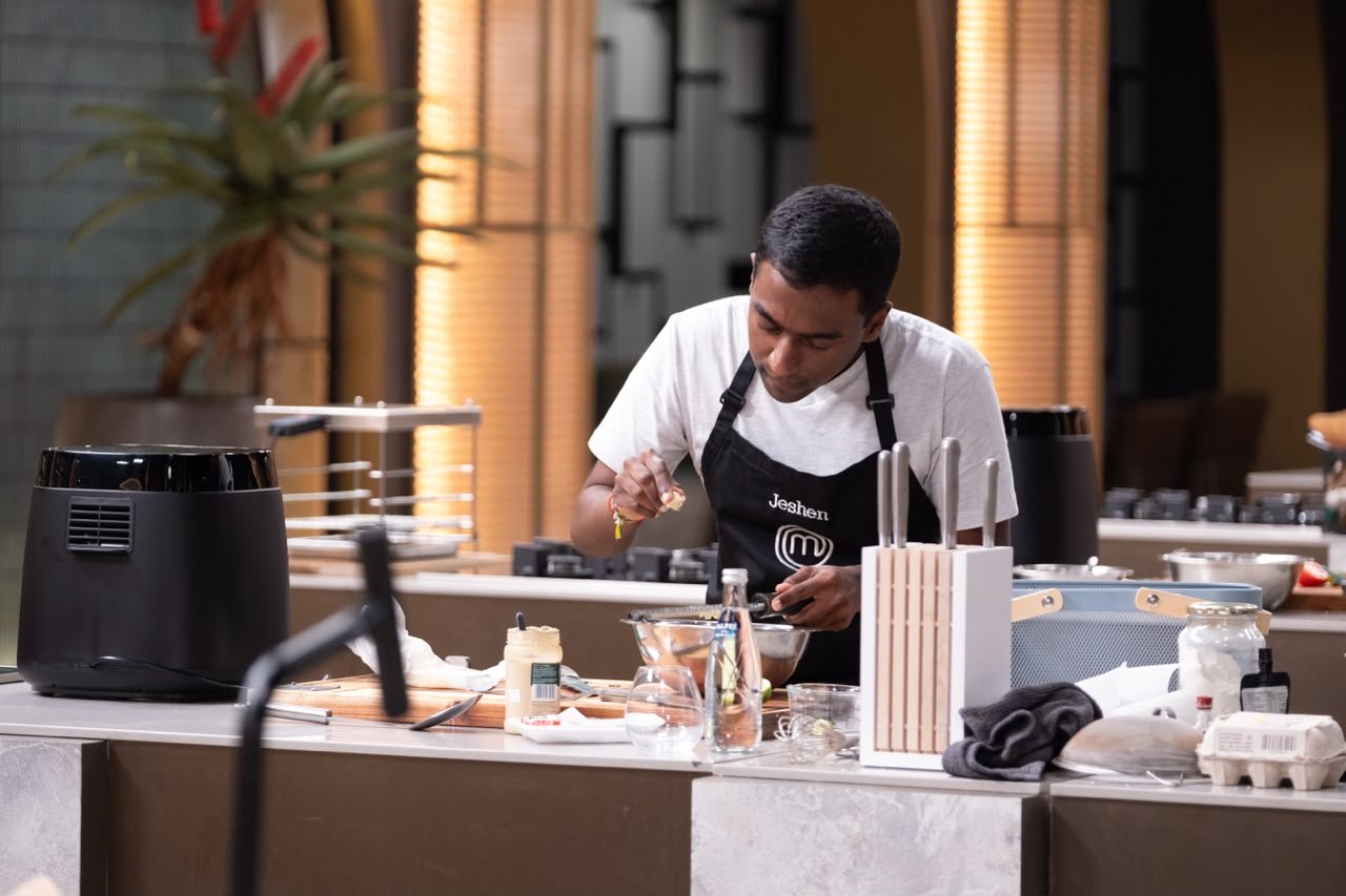 Jeshen Govender plating a dish in the MasterChef kitchen