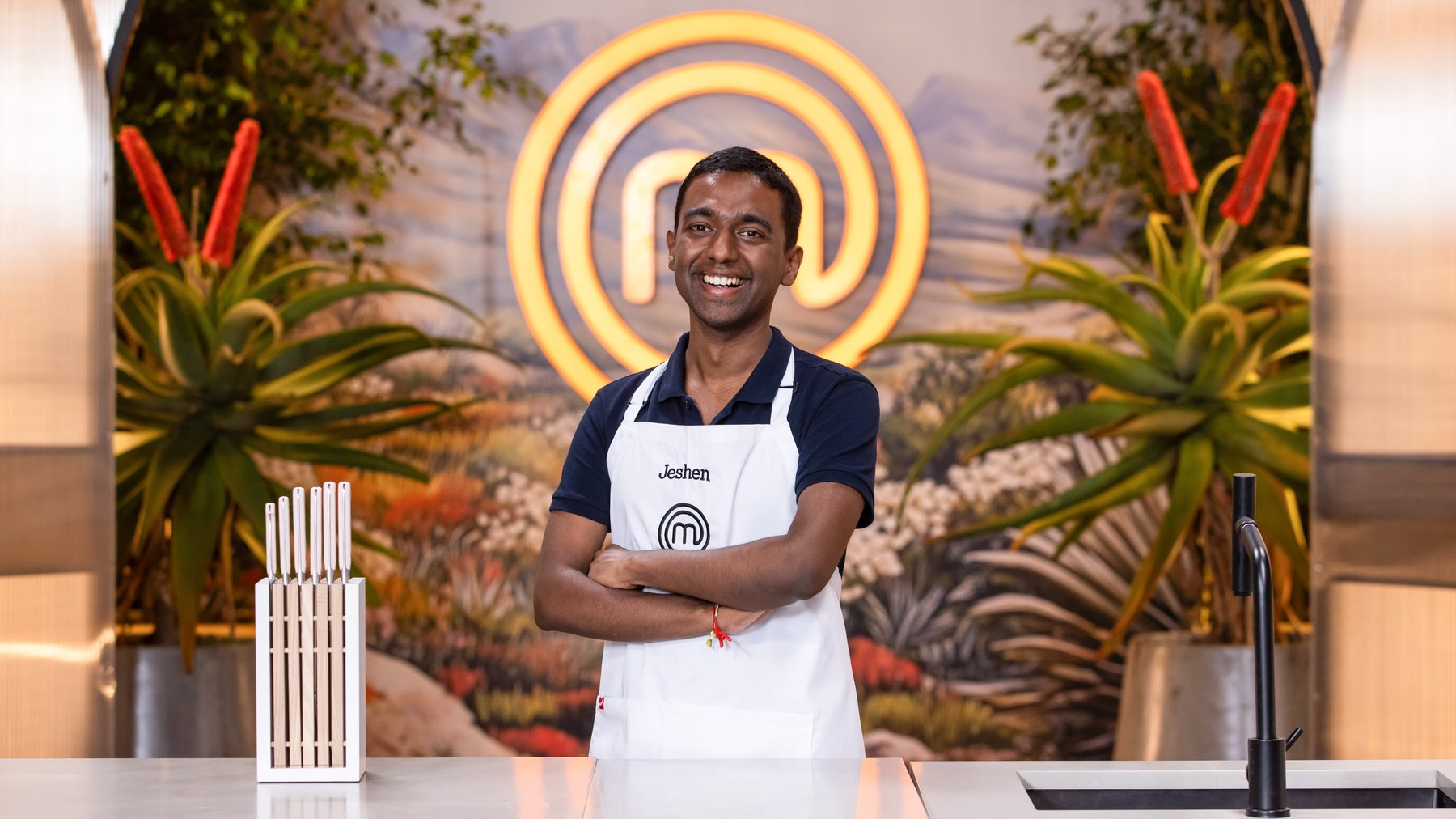 Jeshen Govender in an apron with arms folded